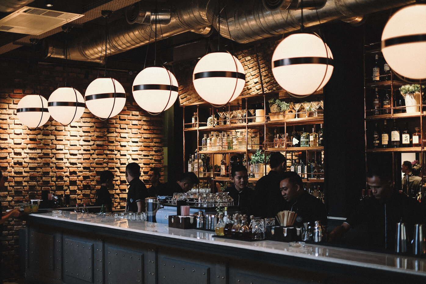 Tampak area bar dari Hurricane’s Grill dipenuhi staff dan lampu gantung